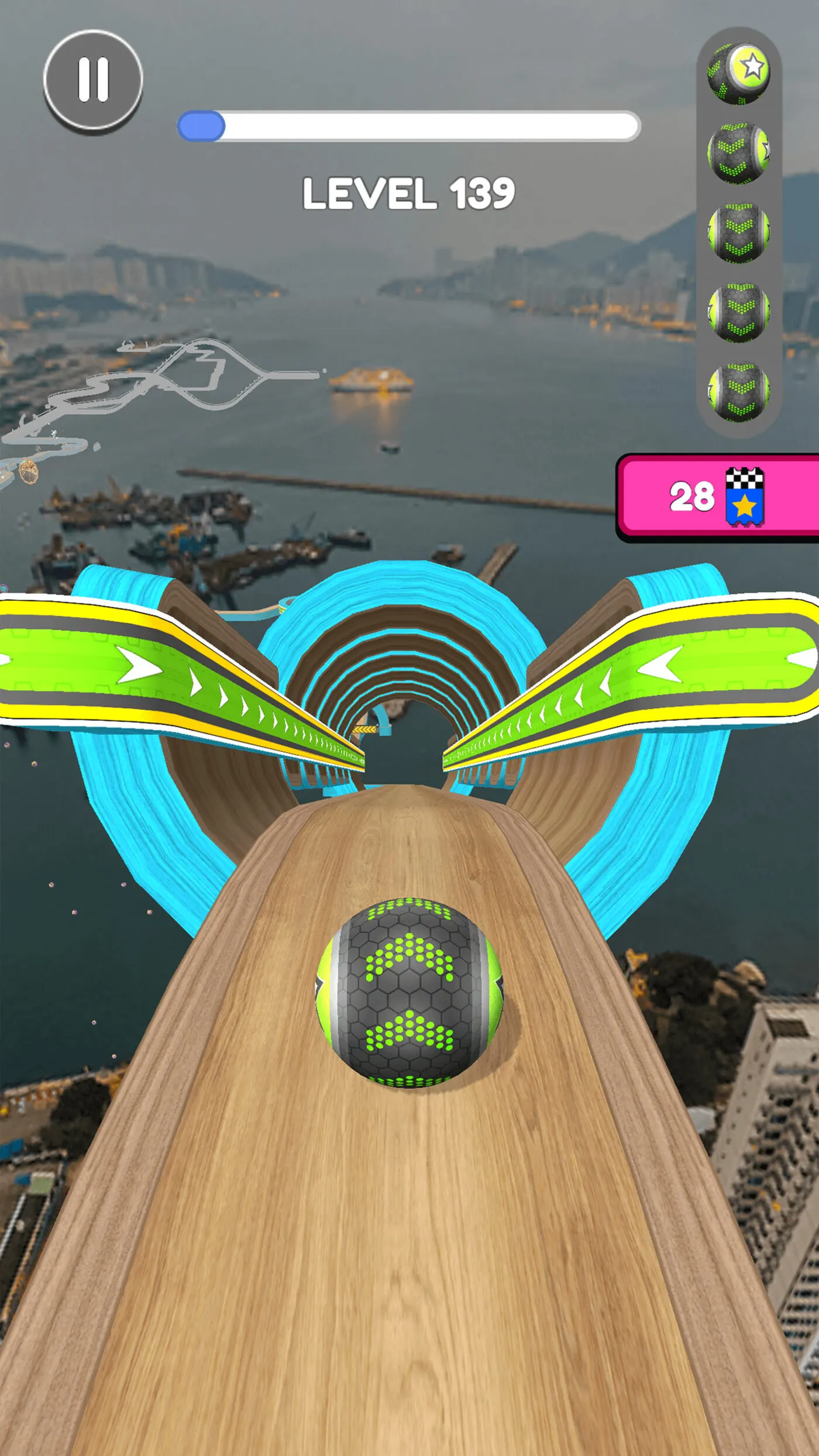 Schermata di gioco di Going Balls: una sfera esagonale verde e nera rotola su una pista di legno sospesa sopra lo skyline di una città, tra due rampe curve blu.